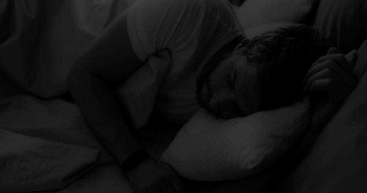 Homme endormi sur un oreiller : dormir la nuit en cage de chasteté